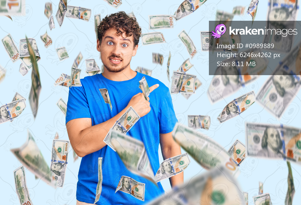 Young handsome man with curly hair wearing casual clothes pointing aside worried and nervous with forefinger, concerned and surprised expression