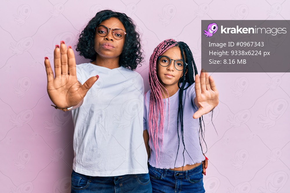 Beautiful african american mother and daughter wearing casual clothes and glasses doing frame using hands palms and fingers, camera perspective 