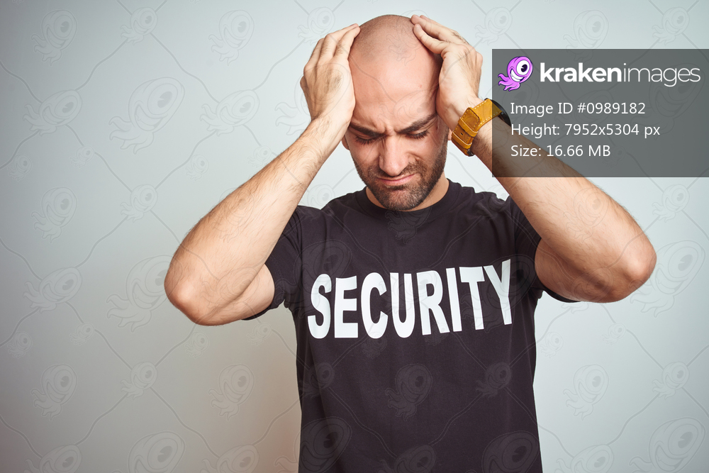 Young safeguard man wearing security uniform over isolated background suffering from headache desperate and stressed because pain and migraine. Hands on head.