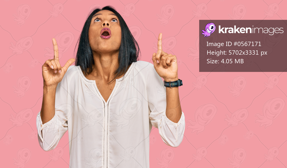 Young african american woman wearing casual clothes amazed and surprised looking up and pointing with fingers and raised arms. 