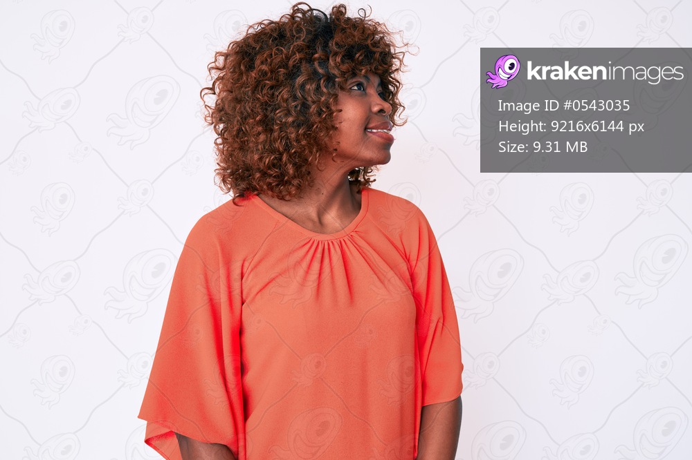 Young african american woman wearing casual clothes looking away to side with smile on face, natural expression. laughing confident. 