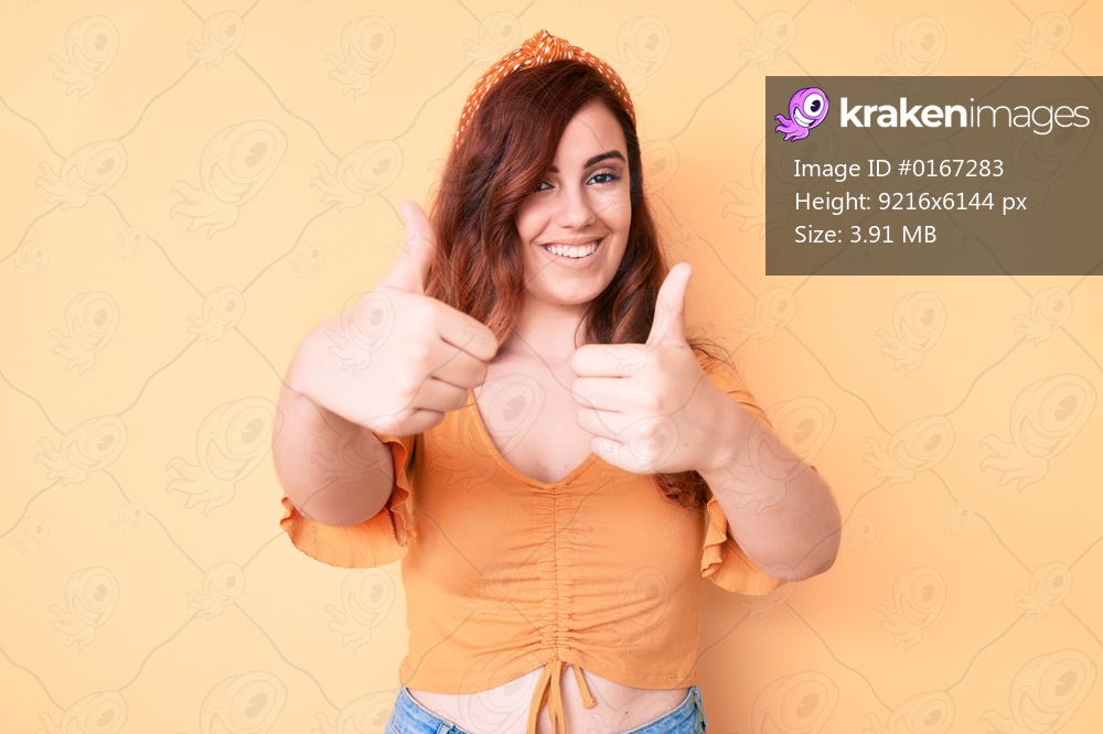 Young beautiful woman wearing casual clothes approving doing positive gesture with hand, thumbs up smiling and happy for success. winner gesture. 