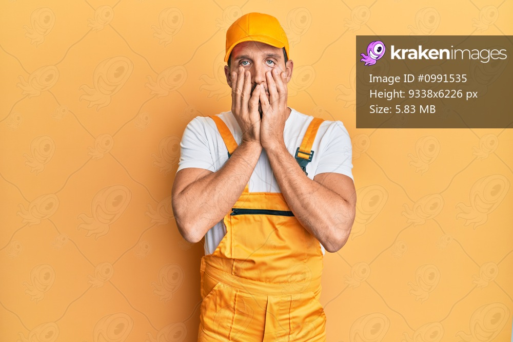 Young handsome man wearing handyman uniform over yellow background tired hands covering face, depression and sadness, upset and irritated for problem 