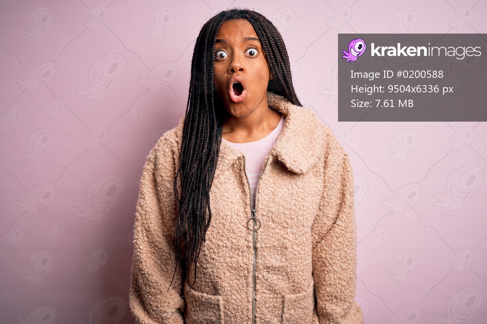 Young african american woman wearing fashion winter coat over pink isolated background afraid and shocked with surprise expression, fear and excited face.