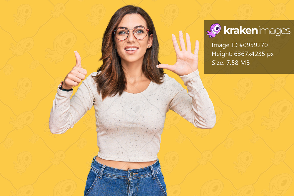 Young brunette woman wearing casual clothes and glasses showing and pointing up with fingers number six while smiling confident and happy. 