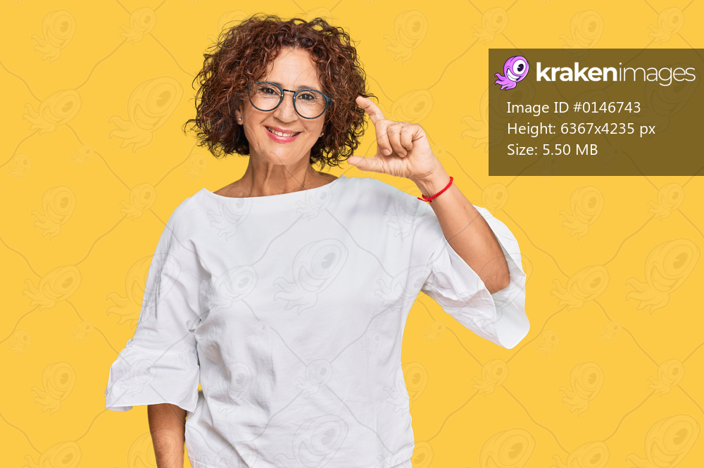 Beautiful middle age mature woman wearing casual clothes and glasses smiling and confident gesturing with hand doing small size sign with fingers looking and the camera. measure concept. 
