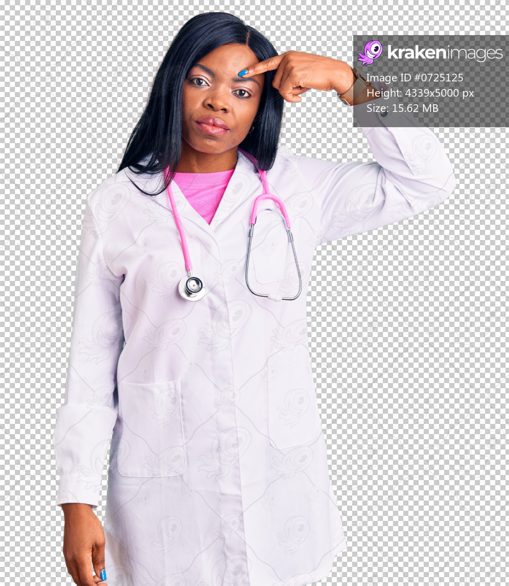 Young african american woman wearing doctor stethoscope pointing unhappy to pimple on forehead, ugly infection of blackhead. acne and skin problem