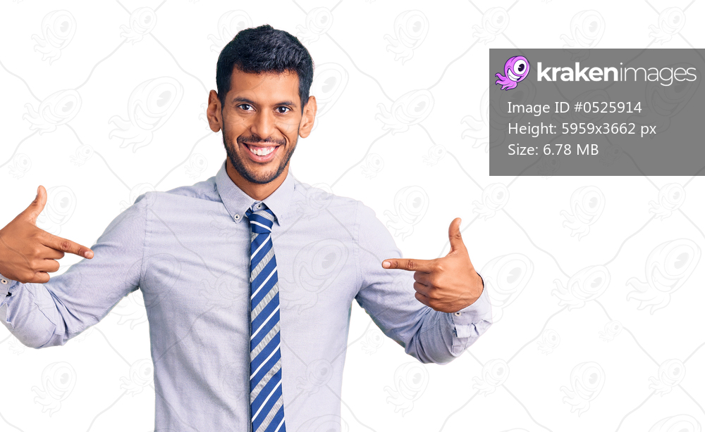 Young latin man wearing business clothes looking confident with smile on face, pointing oneself with fingers proud and happy. 