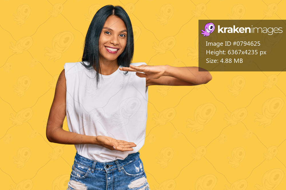 Young african american woman wearing casual clothes gesturing with hands showing big and large size sign, measure symbol. smiling looking at the camera. measuring concept. 