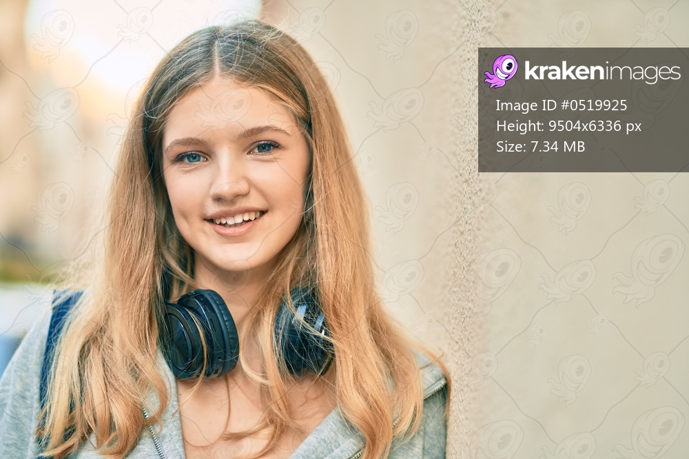 Beautiful caucasian student teenager smiling happy using headphones at the city.