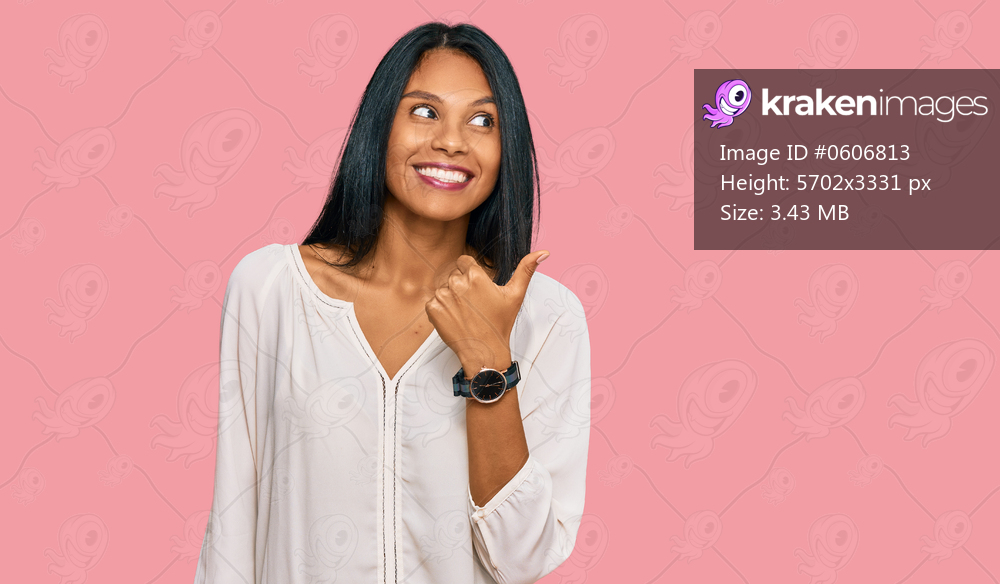 Young african american woman wearing casual clothes smiling with happy face looking and pointing to the side with thumb up. 