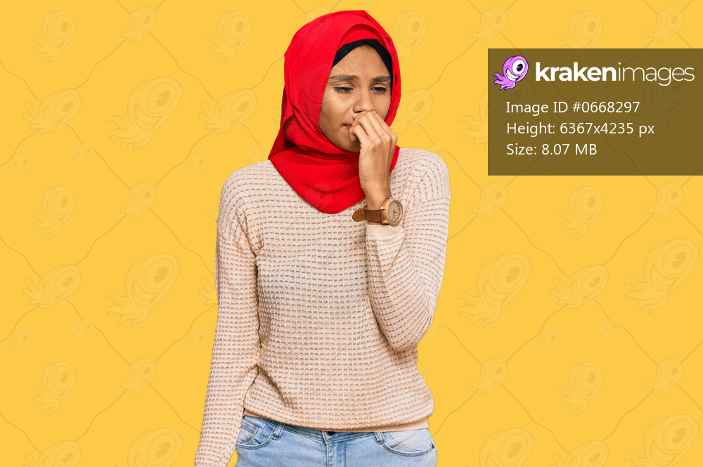 Young african american woman wearing traditional islamic hijab scarf smelling something stinky and disgusting, intolerable smell, holding breath with fingers on nose. bad smell 
