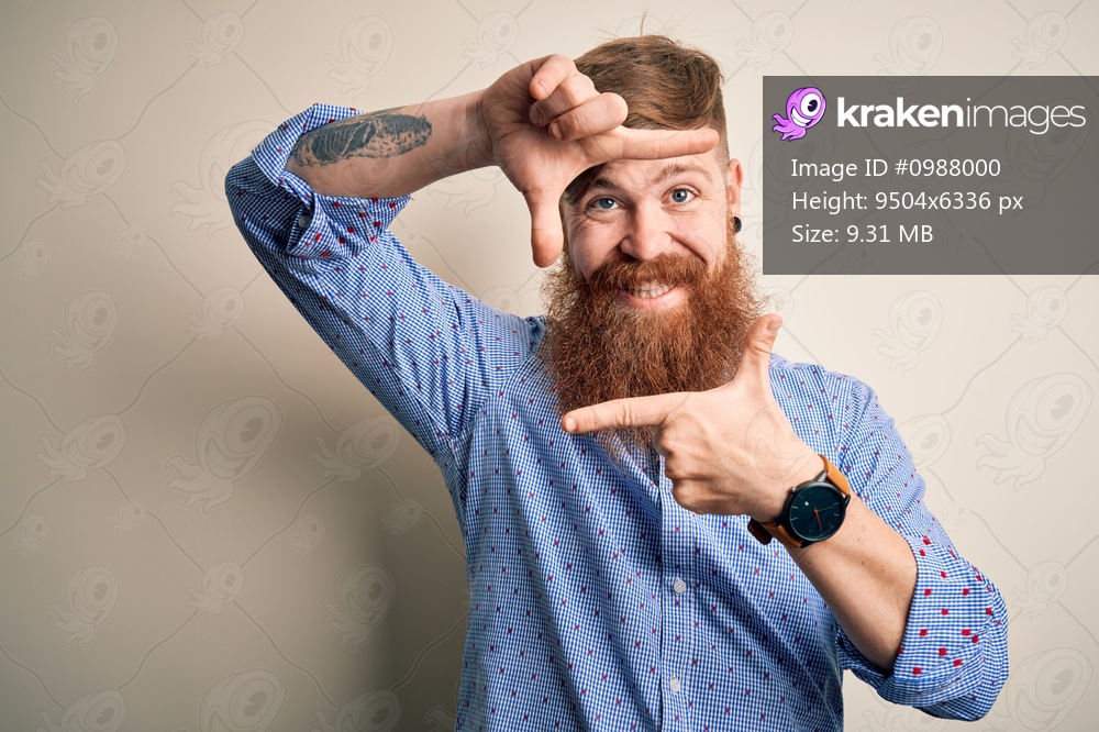Handsome Irish redhead business man with beard standing over isolated background smiling making frame with hands and fingers with happy face. Creativity and photography concept.