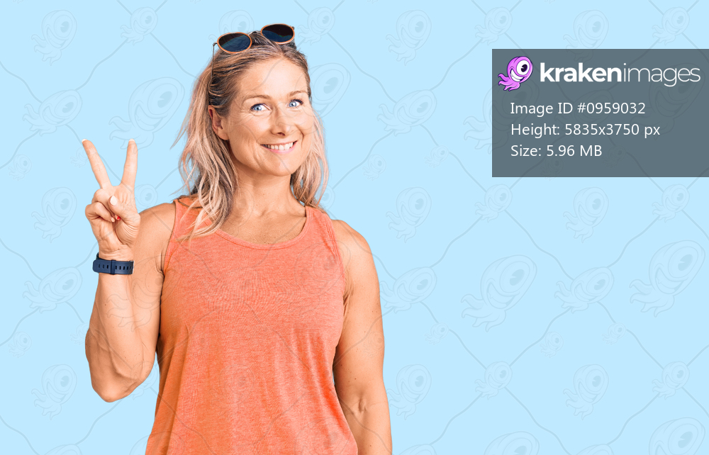 Middle age fit blonde woman wearing casual summer clothes and sunglasses smiling looking to the camera showing fingers doing victory sign. number two. 
