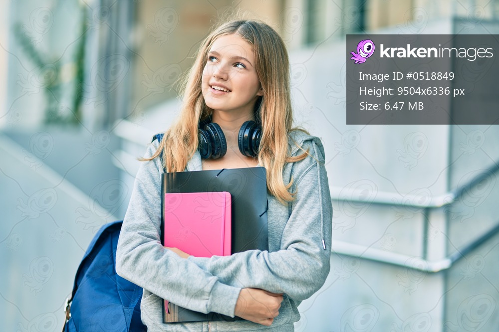Beautiful caucasian student teenager smiling happy using headphones at the city.