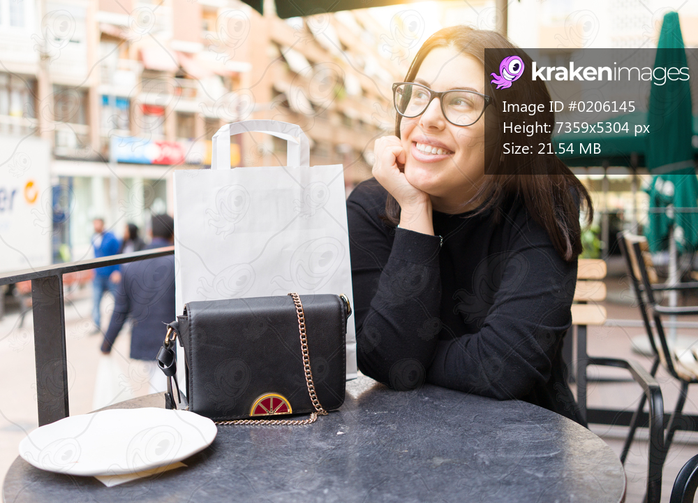 Beautiful young woman smiling happy sitting at the cafeteria of the town
