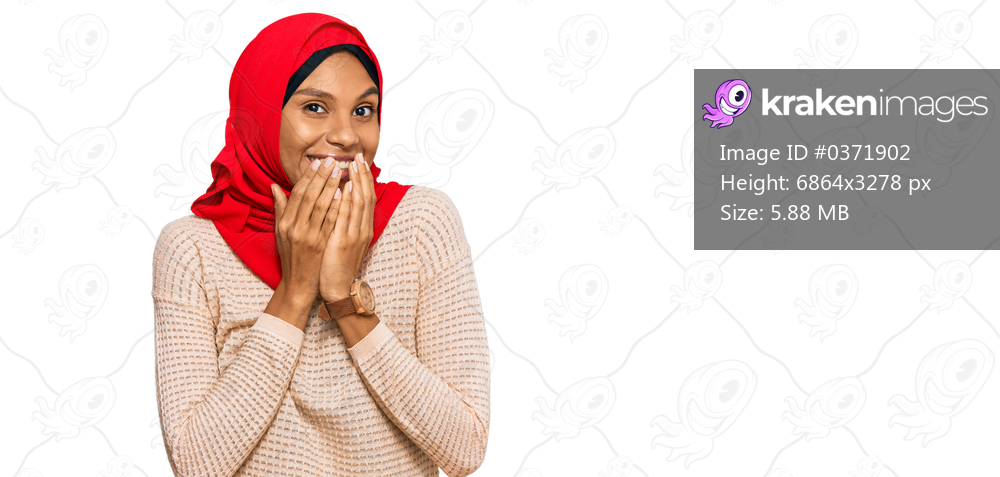 Young african american woman wearing traditional islamic hijab scarf laughing and embarrassed giggle covering mouth with hands, gossip and scandal concept 
