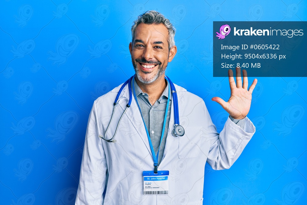Middle age grey-haired man wearing doctor uniform and stethoscope showing and pointing up with fingers number five while smiling confident and happy. 