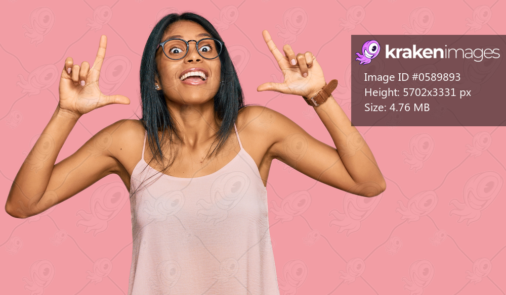 Young african american woman wearing casual clothes and glasses smiling amazed and surprised and pointing up with fingers and raised arms. 