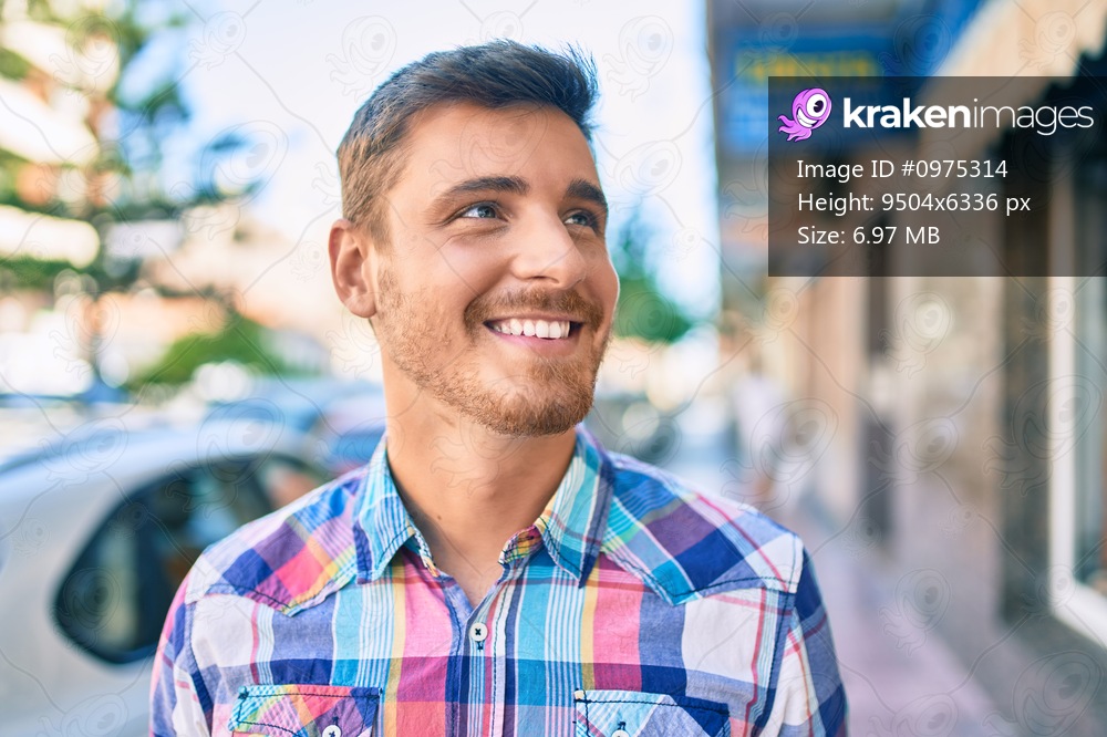 Young caucasian man smiling happy walking at the city.