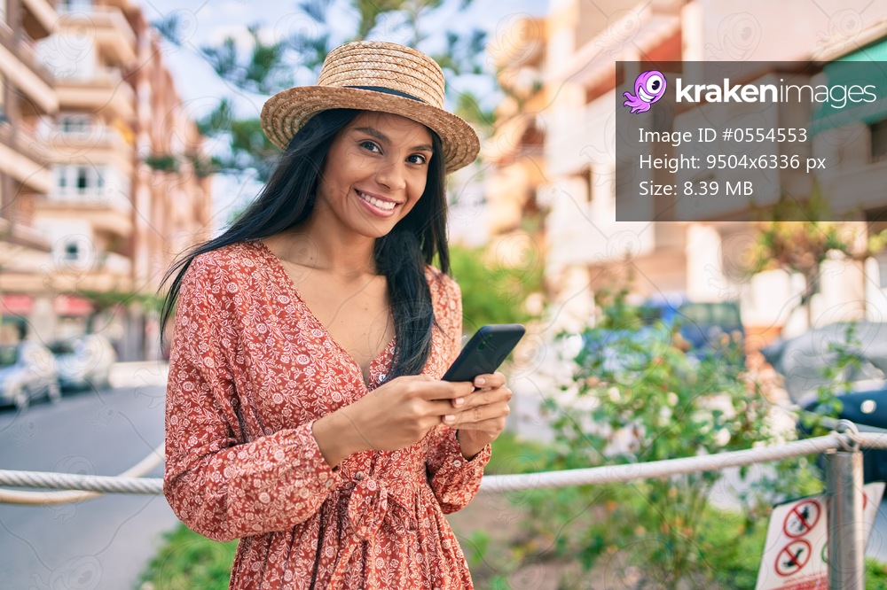 Young african american tourist woman on vacation smiling happy using smartphone at the city.