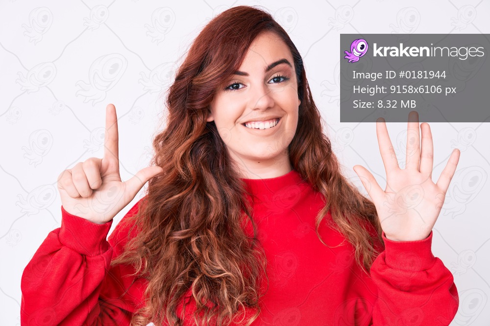 Young beautiful woman wearing casual clothes showing and pointing up with fingers number seven while smiling confident and happy. 