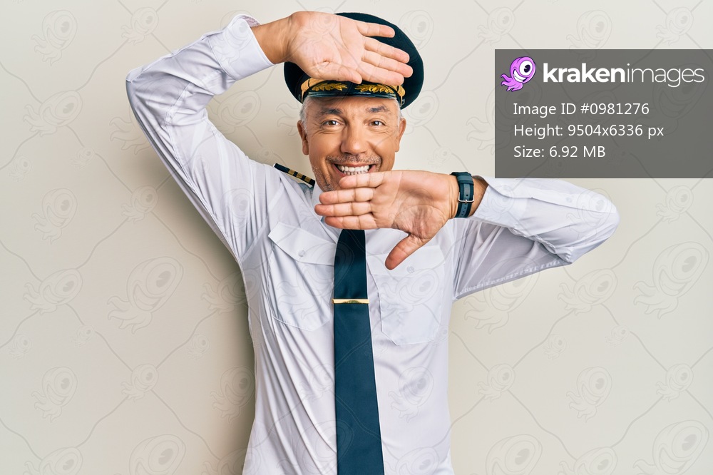 Handsome middle age mature man wearing airplane pilot uniform smiling cheerful playing peek a boo with hands showing face. surprised and exited 