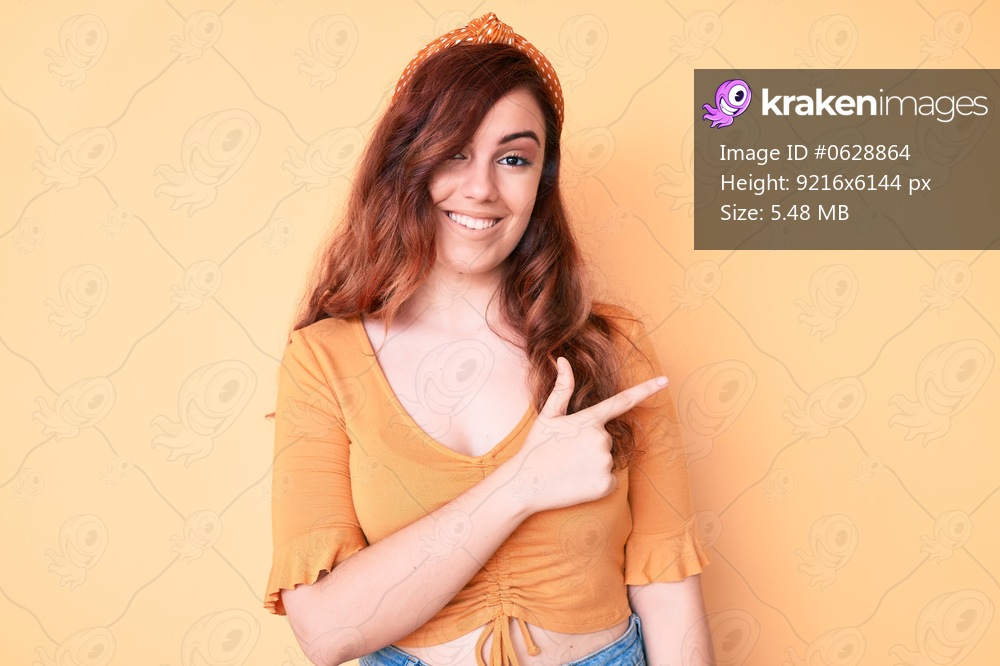 Young beautiful woman wearing casual clothes cheerful with a smile of face pointing with hand and finger up to the side with happy and natural expression on face 