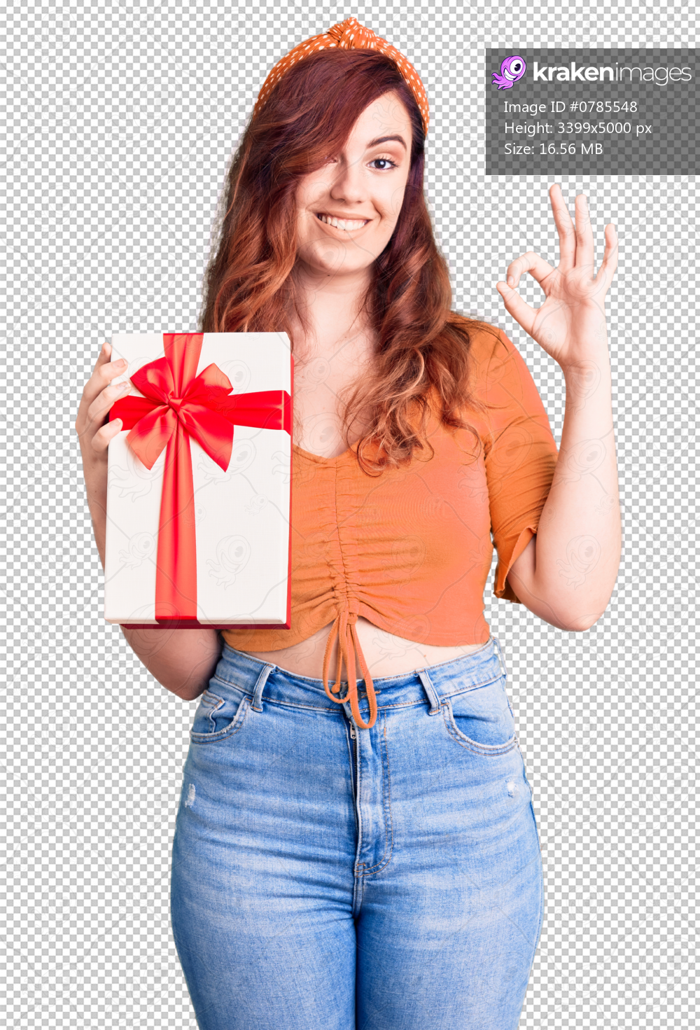 Young beautiful woman holding gift doing ok sign with fingers, smiling friendly gesturing excellent symbol