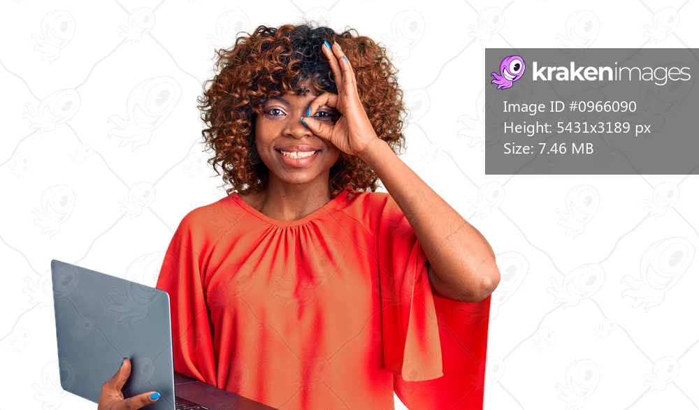 Young african american woman working using computer laptop smiling happy doing ok sign with hand on eye looking through fingers 