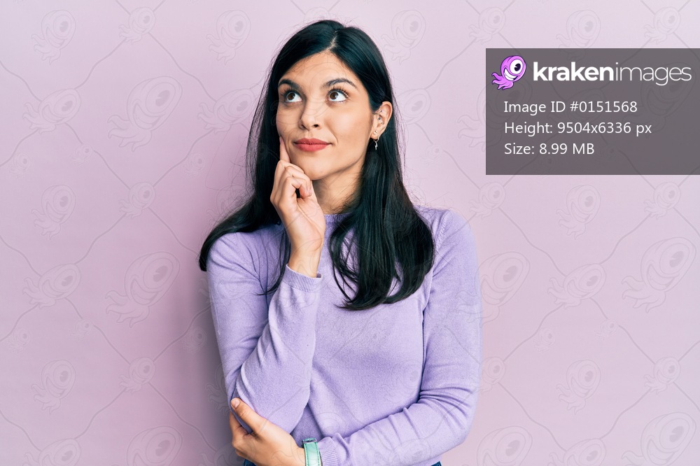 Young hispanic woman wearing casual clothes with hand on chin thinking about question, pensive expression. smiling and thoughtful face. doubt concept. 