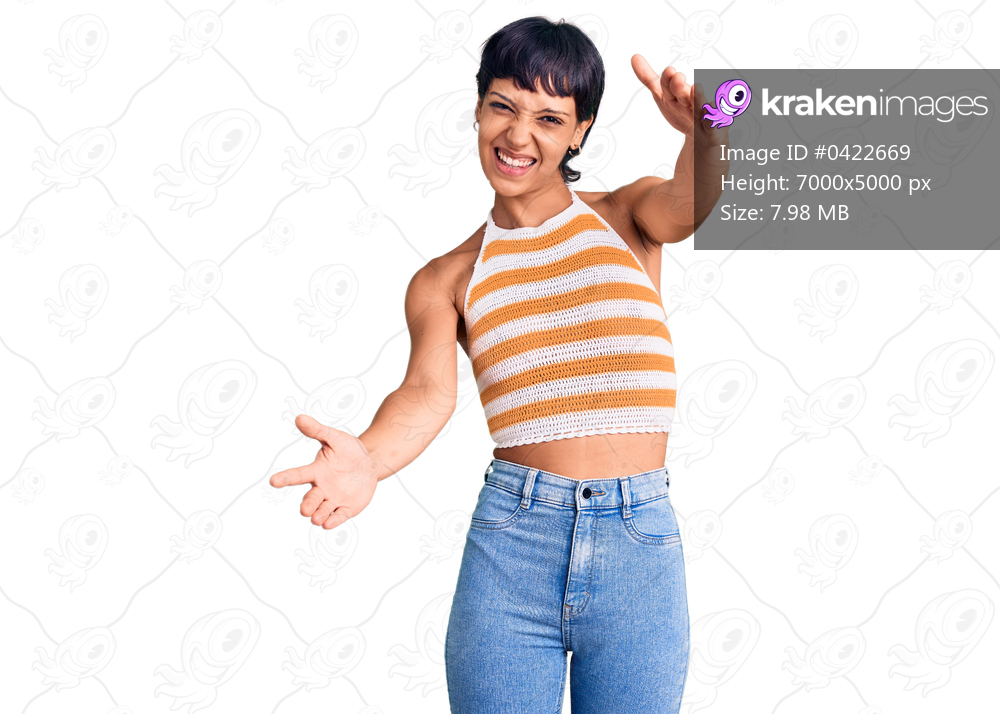 Young brunette woman with short hair wearing casual clothes looking at the camera smiling with open arms for hug. cheerful expression embracing happiness. 