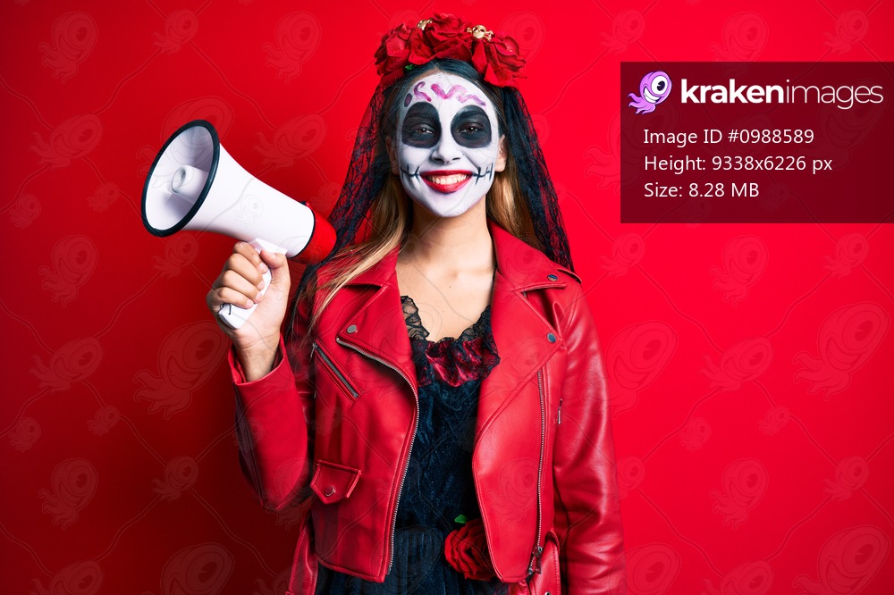 Woman wearing day of the dead costume using megaphone smiling with a happy and cool smile on face. showing teeth. 