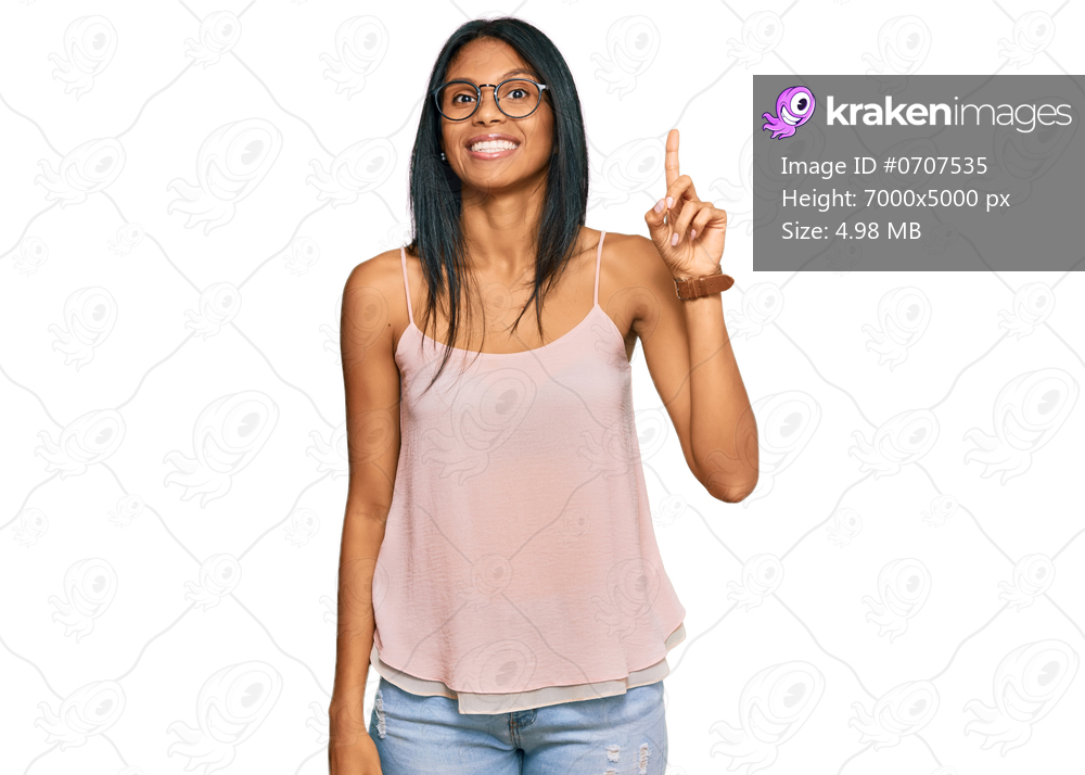 Young african american woman wearing casual clothes and glasses showing and pointing up with finger number one while smiling confident and happy. 