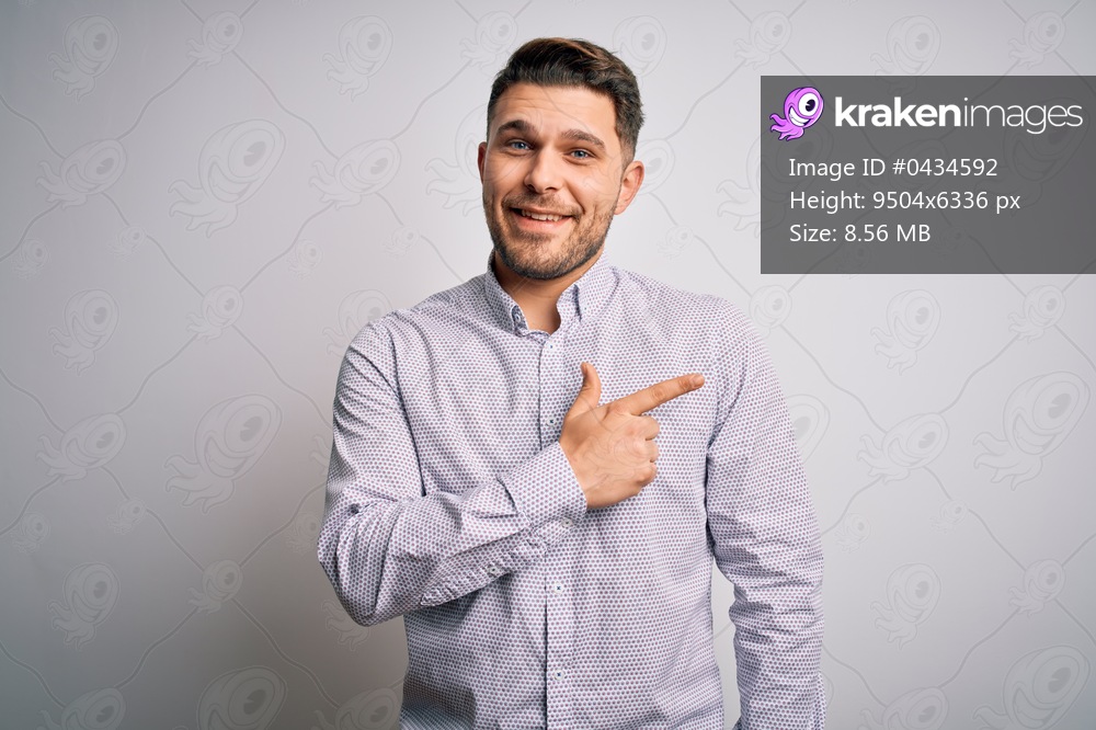 Young business man with blue eyes standing over isolated background cheerful with a smile of face pointing with hand and finger up to the side with happy and natural expression on face