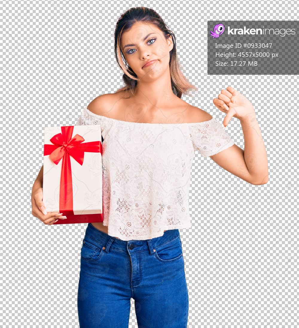 Young beautiful woman holding gift with angry face, negative sign showing dislike with thumbs down, rejection concept
