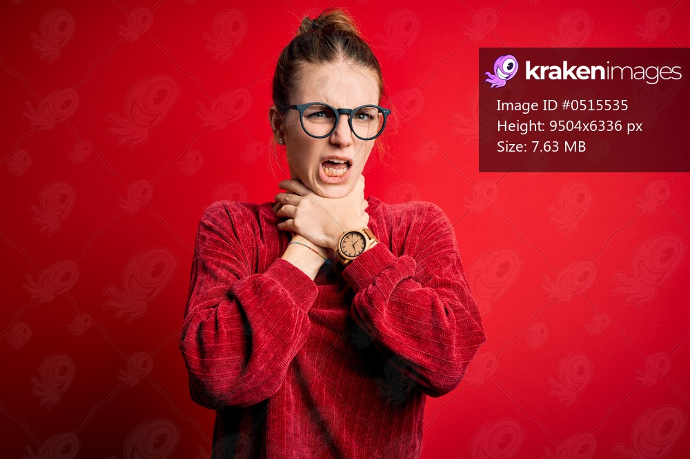 Young beautiful redhead woman wearing casual sweater over isolated red background shouting suffocate because painful strangle. Health problem. Asphyxiate and suicide concept.