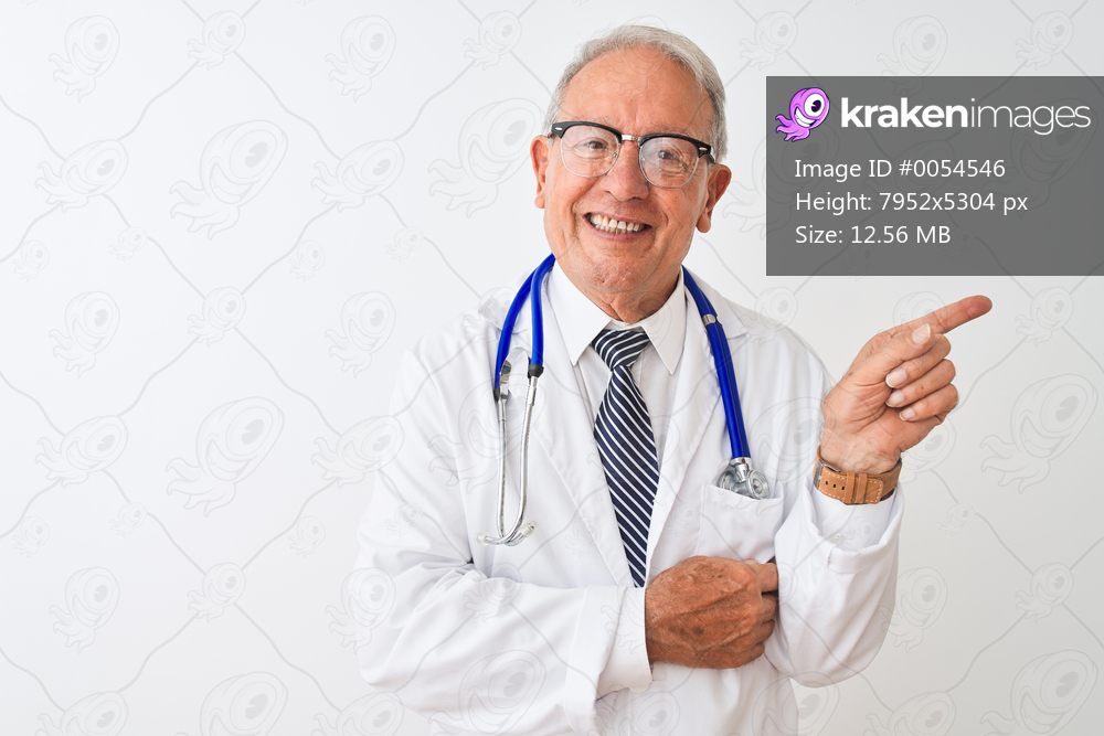 Senior grey-haired doctor man wearing stethoscope standing over isolated white background with a big smile on face, pointing with hand and finger to the side looking at the camera.