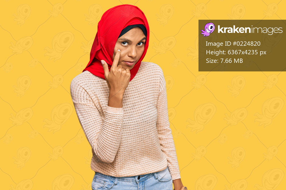 Young african american woman wearing traditional islamic hijab scarf pointing to the eye watching you gesture, suspicious expression 