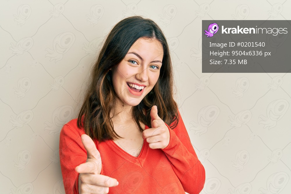 Young brunette woman wearing casual clothes pointing fingers to camera with happy and funny face. good energy and vibes. 