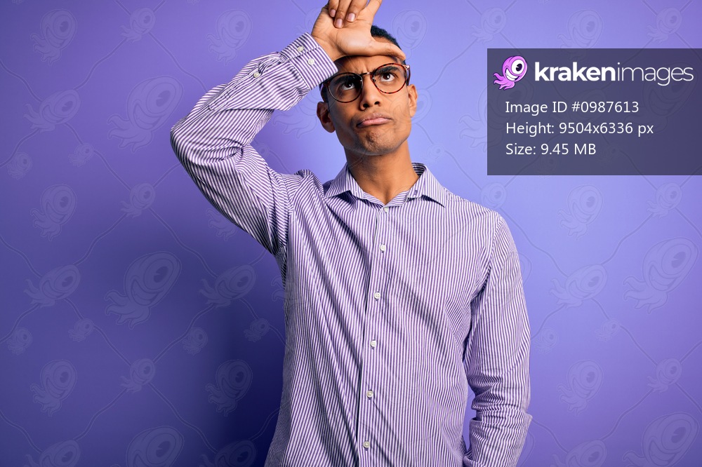 Handsome african american man wearing striped shirt and glasses over purple background making fun of people with fingers on forehead doing loser gesture mocking and insulting.