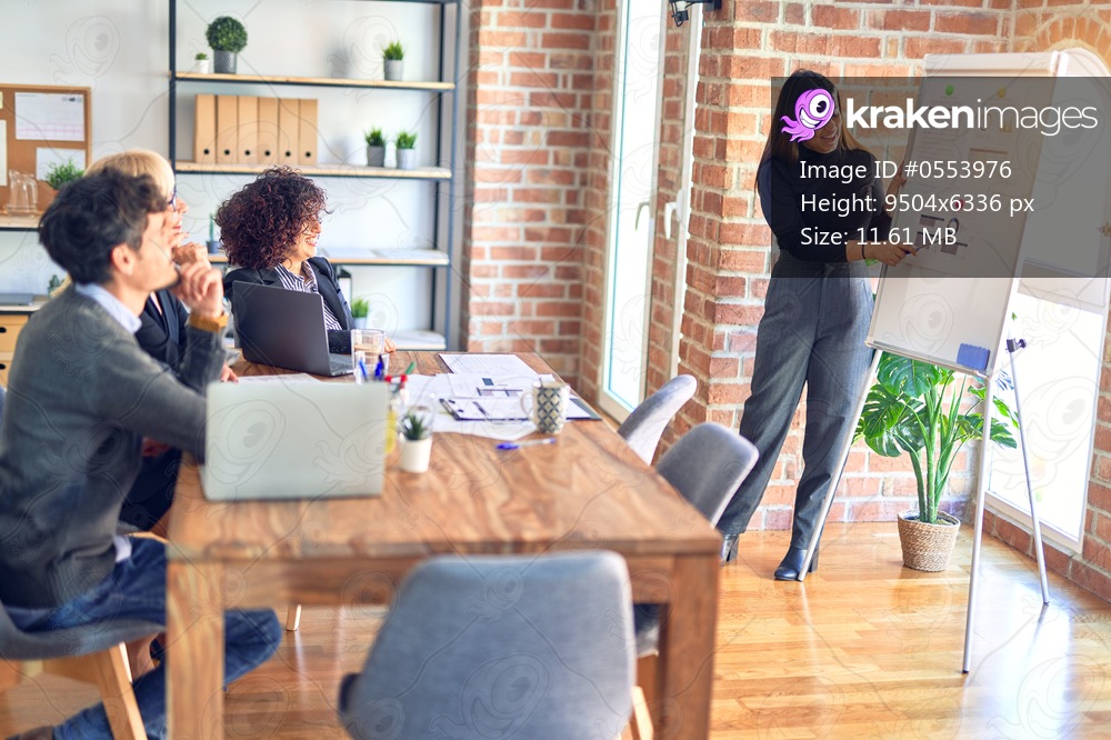 Group of business workers working together in a meeting. One of them making presentation to colleagues at the office
