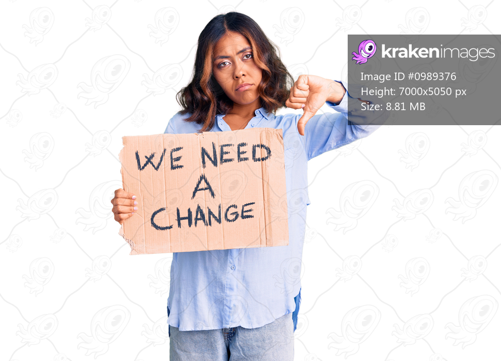 Young beautiful mixed race woman holding we need a change banner with angry face, negative sign showing dislike with thumbs down, rejection concept 