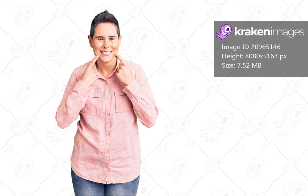 Young woman with short hair wearing casual clothes smiling with open mouth, fingers pointing and forcing cheerful smile 