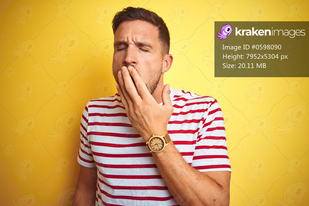 Young handsome man wearing casual red striped t-shirt over yellow isolated background bored yawning tired covering mouth with hand. Restless and sleepiness.