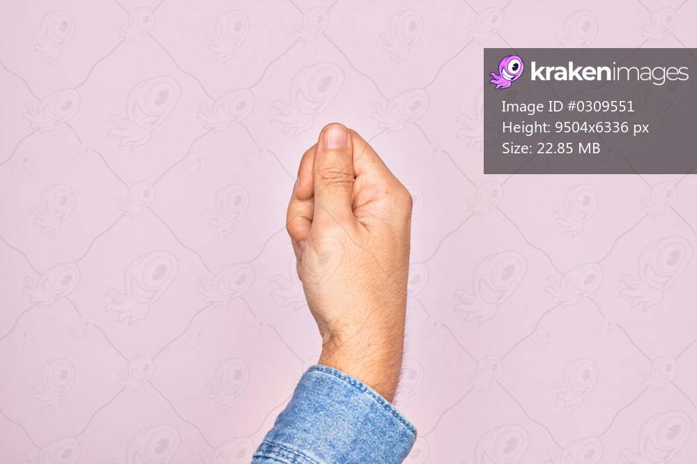 Hand of caucasian young man showing fingers over isolated pink background holding blank space with thumb finger, business and advertising