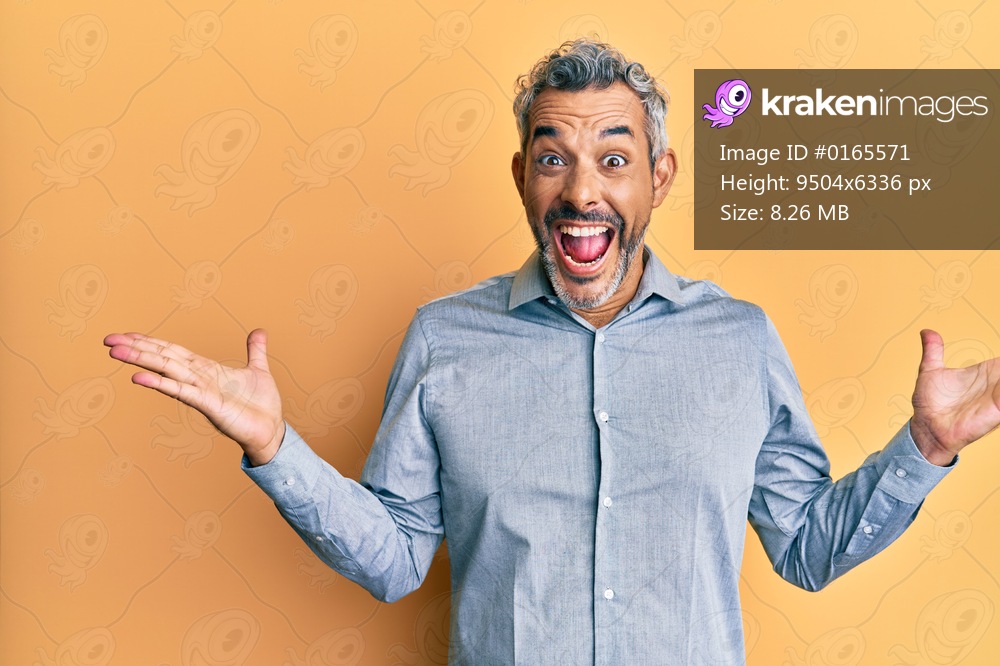 Middle age grey-haired man wearing casual clothes celebrating victory with happy smile and winner expression with raised hands 
