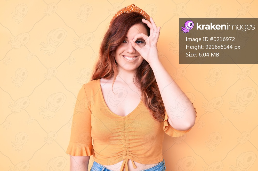 Young beautiful woman wearing casual clothes doing ok gesture with hand smiling, eye looking through fingers with happy face. 