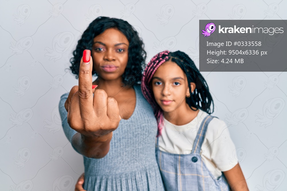 Beautiful african american mother and daughter wearing casual clothes and hugging showing middle finger, impolite and rude fuck off expression 