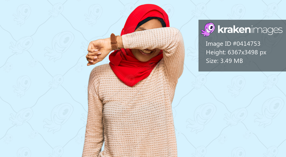 Young african american woman wearing traditional islamic hijab scarf covering eyes with arm smiling cheerful and funny. blind concept. 